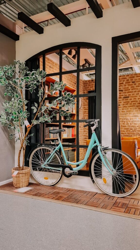 A vintage bicycle placed indoors next to a large window in sunny İstanbul, Türkiye.