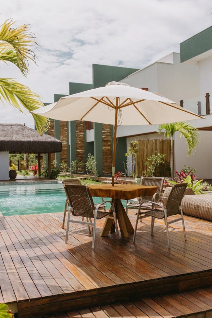 Stylish patio with wooden deck and umbrella by a pool in Bahia, Brazil.